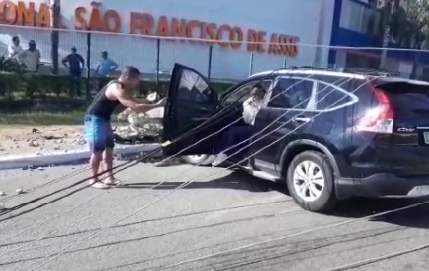 Homem ajuda vítimas a sair do veículo após acidente