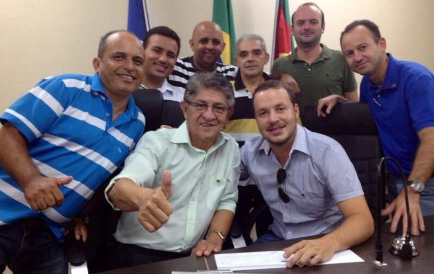 Osvaldo Reis Júnior sentado, à direita da foto
