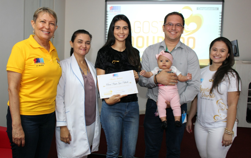 Equipe entrega certificado de menção honrosa para a doadora de leite.