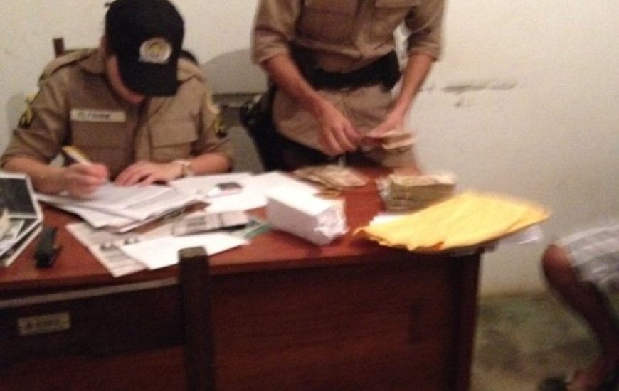 Policiais conferem o dinheiro apreendido