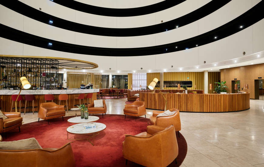 Lobby de resort de luxo com teto listrado, paredes e detalhes em dourado