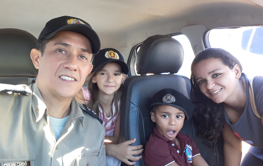 Davi Miguel, mãe e irmã conhecem interior da viatura policial.