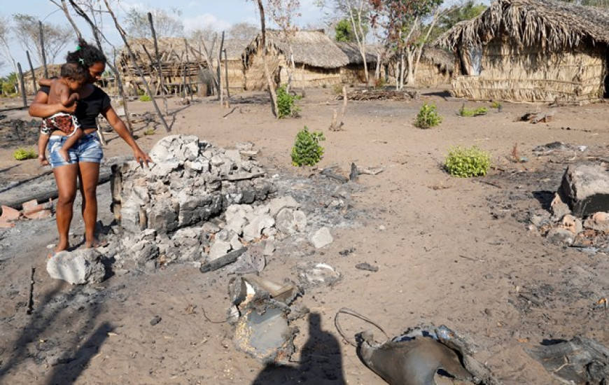 Moradora de acampamento mostra as cinzas do incêndio